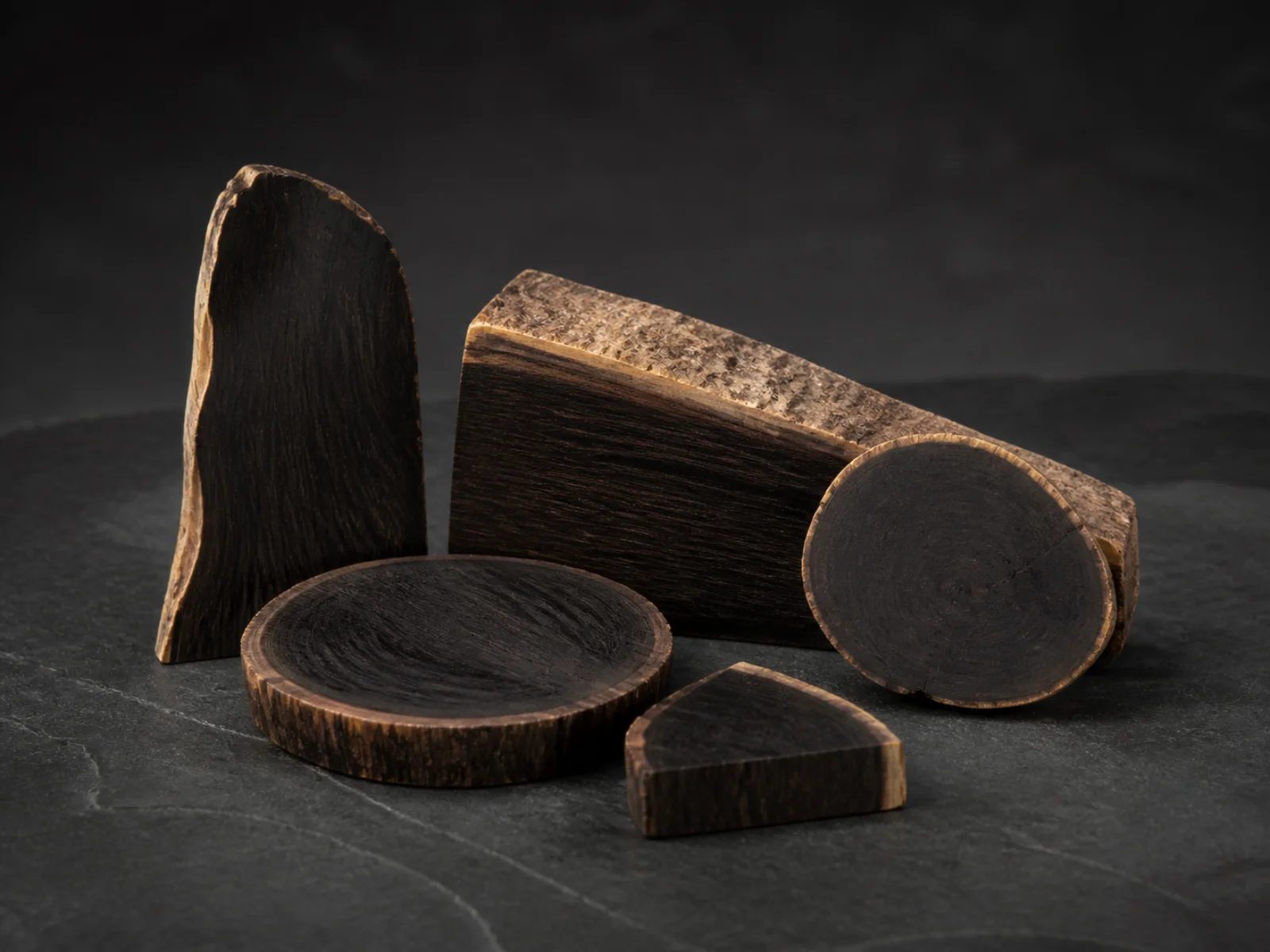 Sezioni di legno di ebano scuro su una superficie antracite