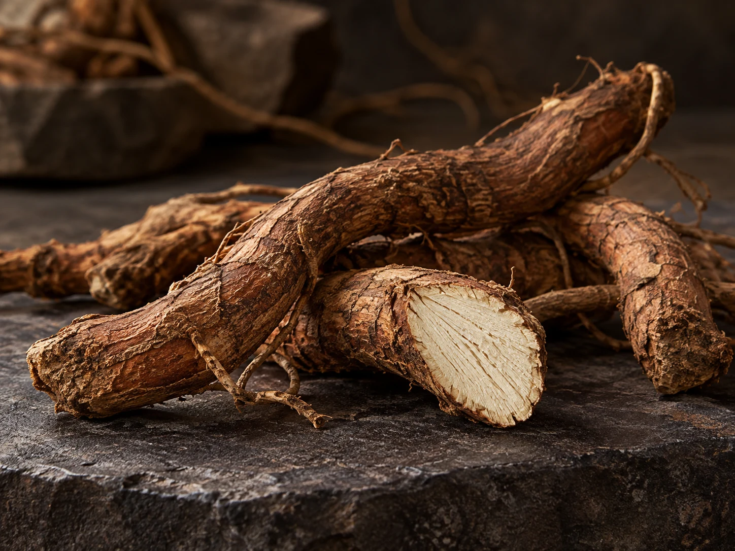 Radici aromatiche dalla corteccia bruna e dal cuore chiaro su una pietra scura