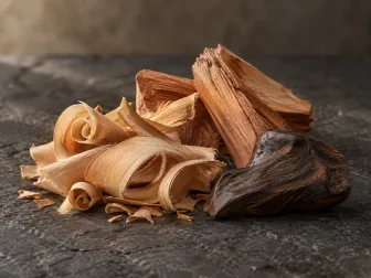 Trucioli chiari e frammenti di legni aromatici dalle diverse venature su pietra scura