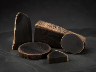Sezioni di legno di ebano scuro su una superficie antracite